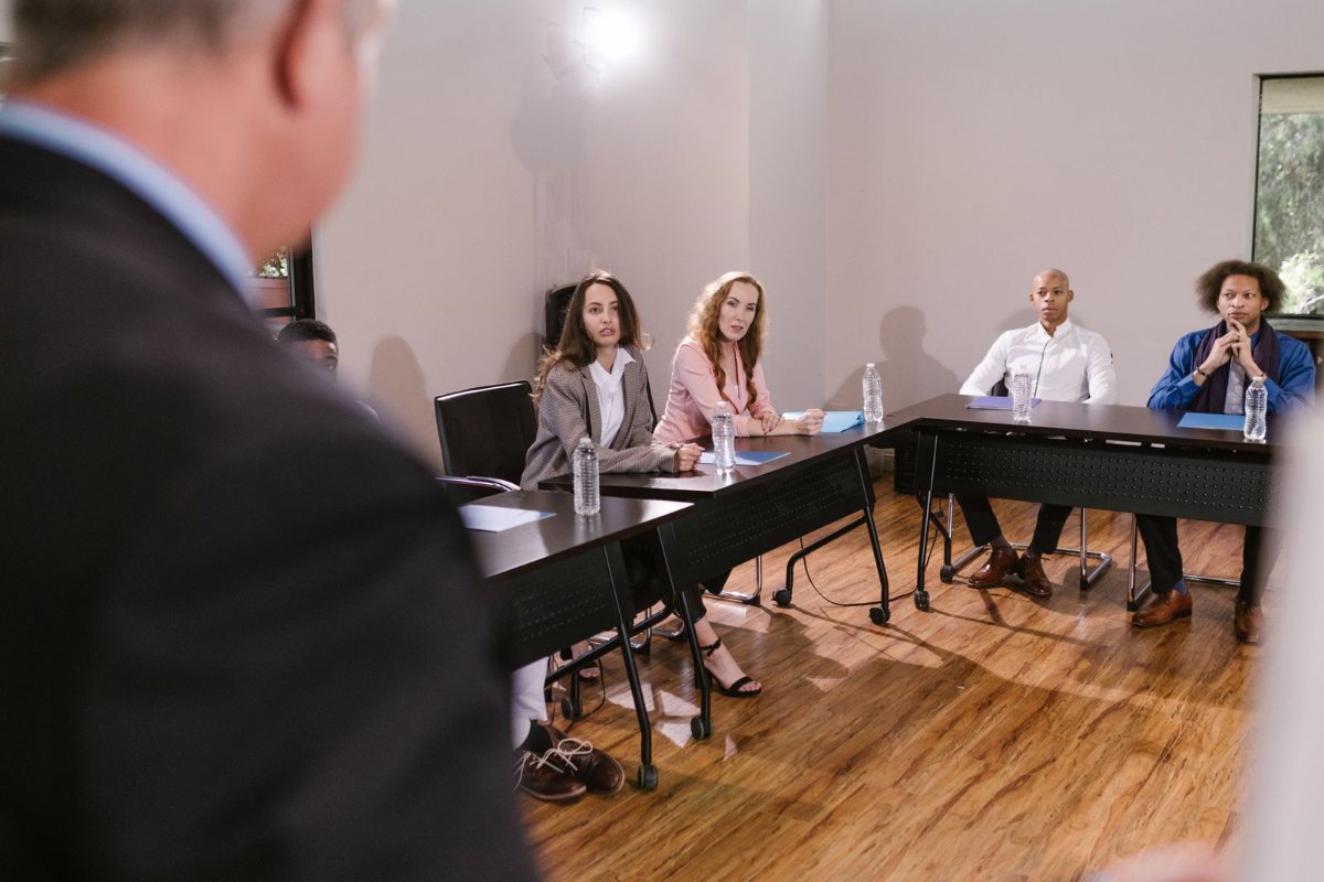 Reuniao de acionistas em torno de uma mesa, representando uma assembleia de empresa