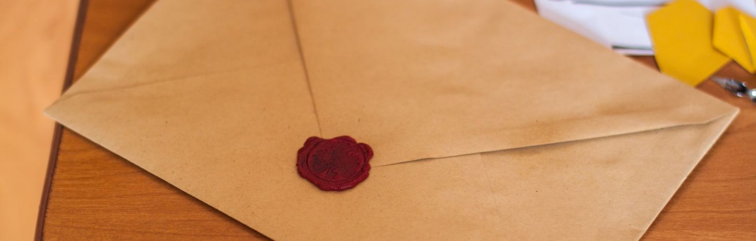 Envelope de papel pardo lacrado sobre a mesa, ilustrando um comunicado oficial ao mercado