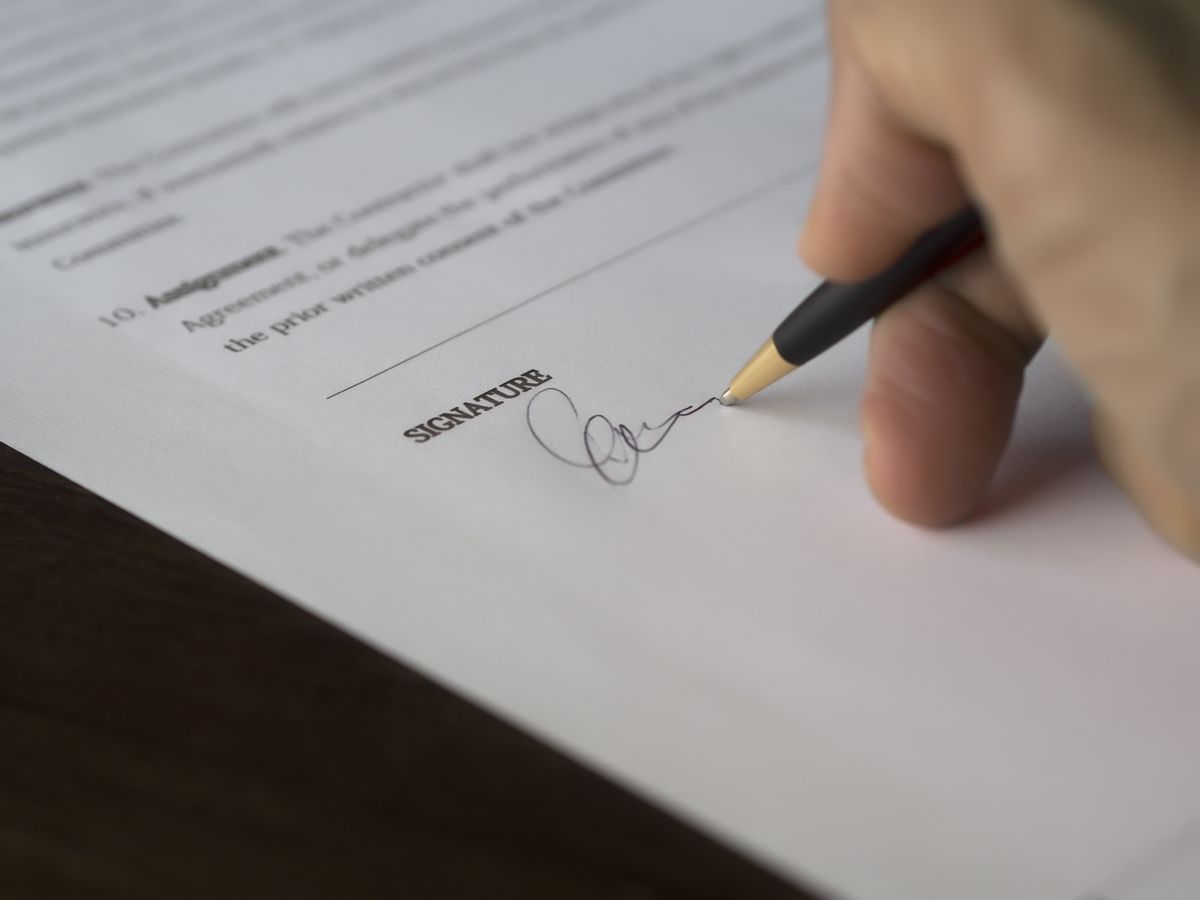 Pessoa assinando um contrato de emissao de divida no mercado
