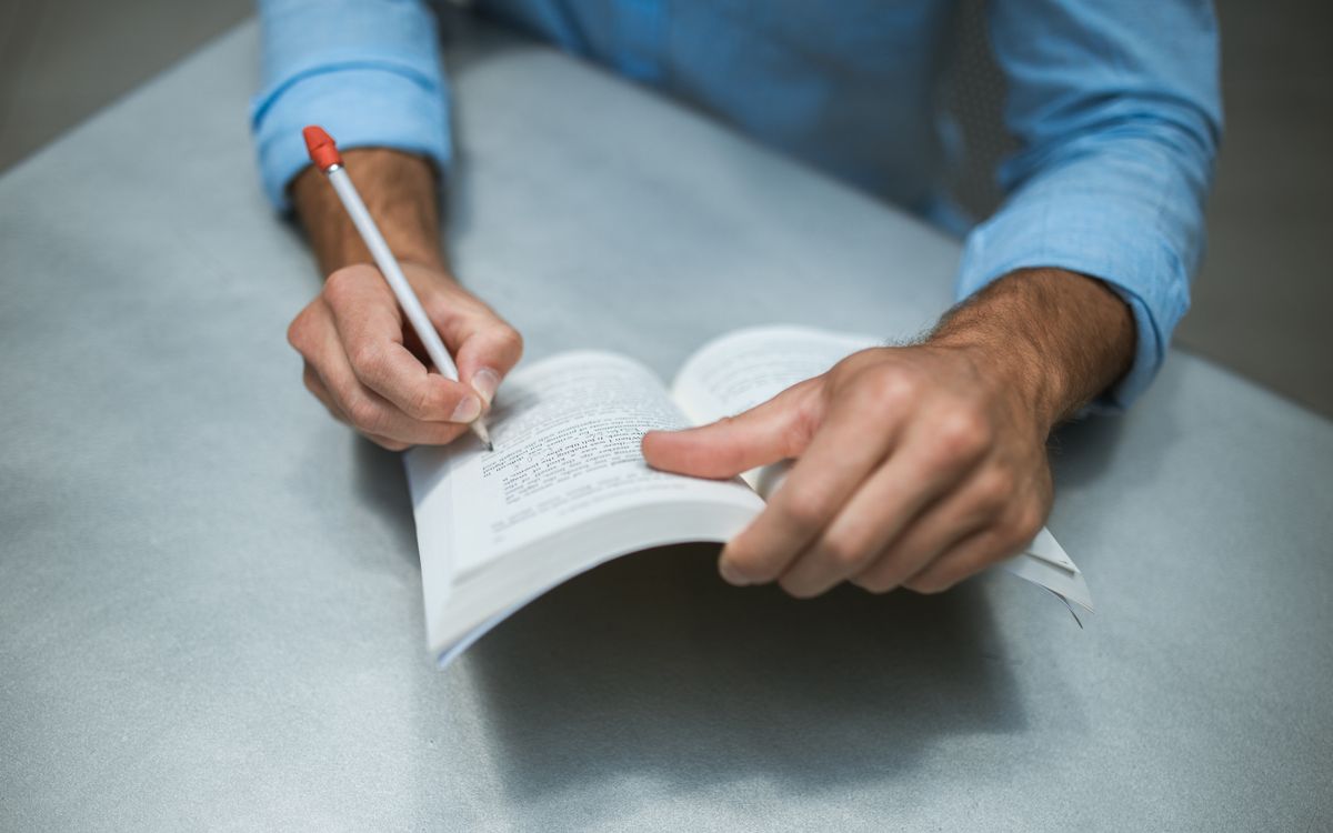 Pessoa lendo um documento extenso com atenção