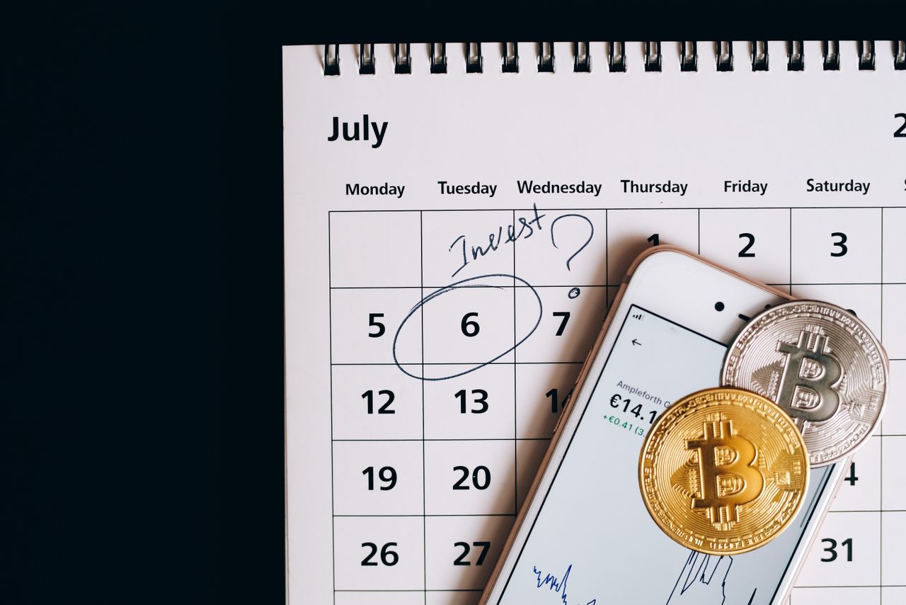 Calendário do mês com moedas sobre as datas, representando o anúncio de proventos