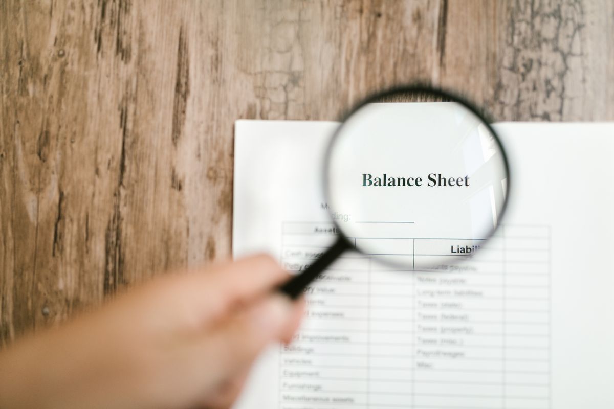 Lupa sobre um balanco patrimonial destacando o valor contabil